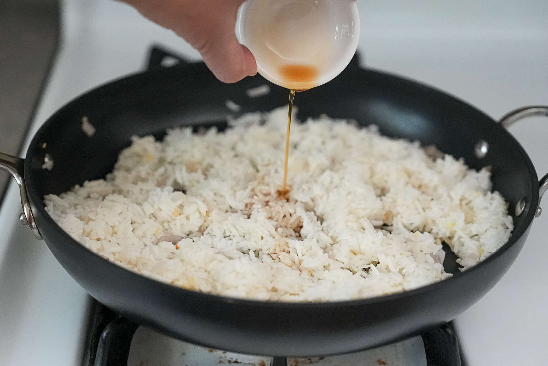 Add the rice and season with fish sauce, soy sauce