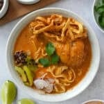 Khao Soi recipe with chicken, fried noodles, and condiments
