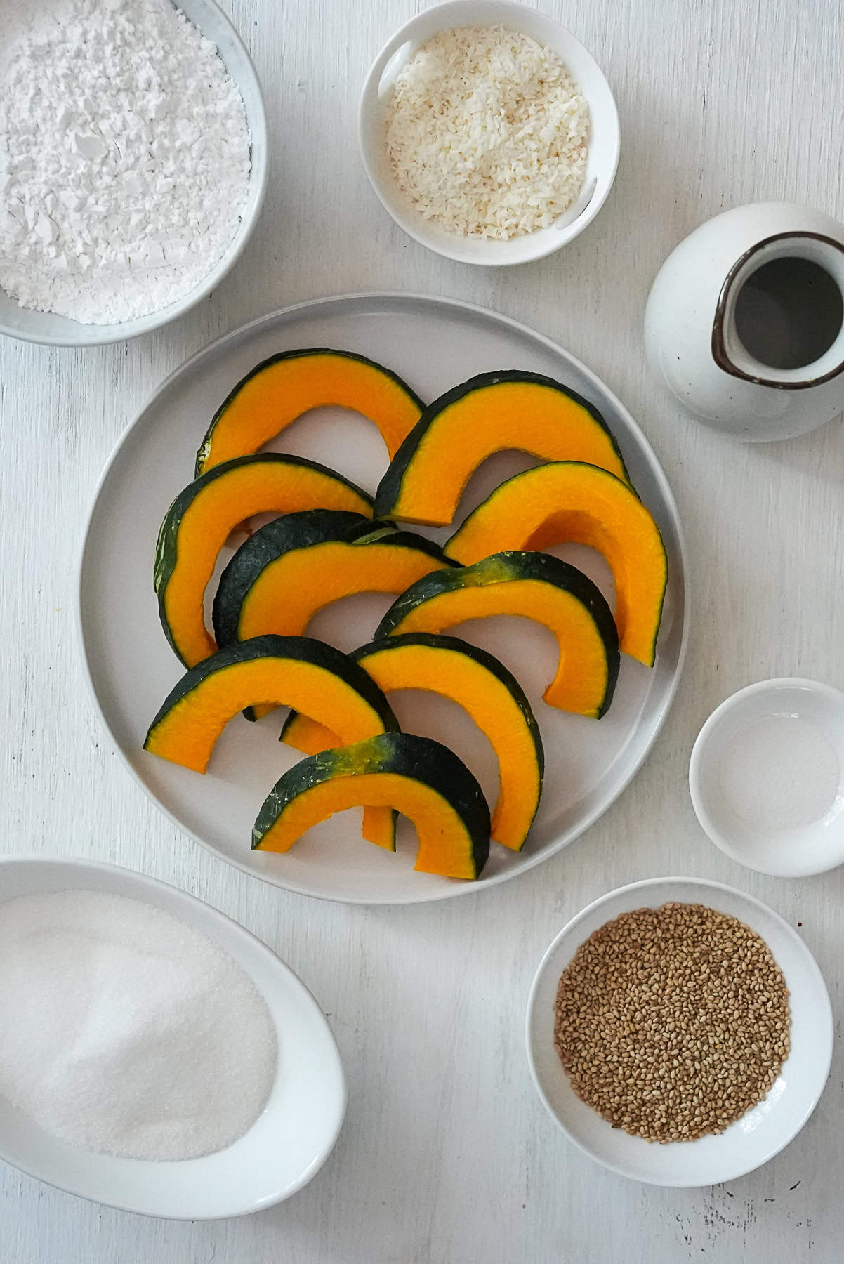 Ingredients for Thai Fried Pumpkin including kabocha squash, rice flour, coconut, club soda, salt, sesame seeds, and sugar