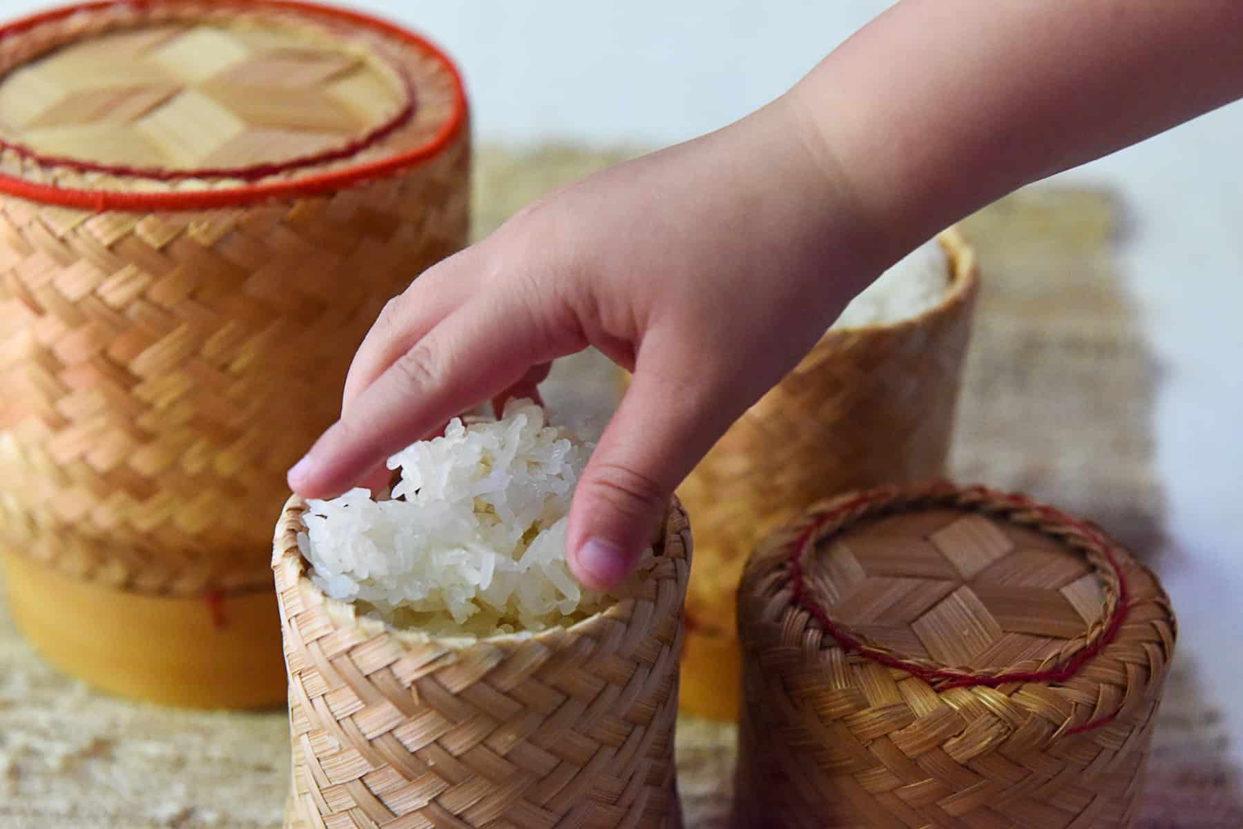 Hand reaching for Sticky Rice