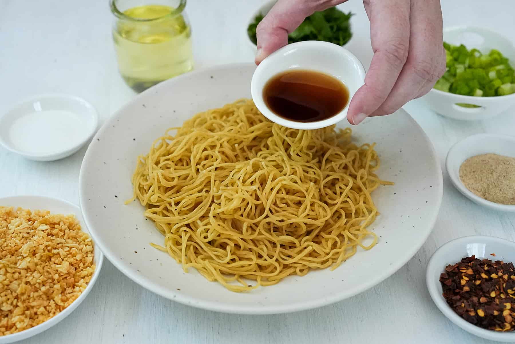 Add fish sauce, sugar, and fried garlic to dry egg noodles