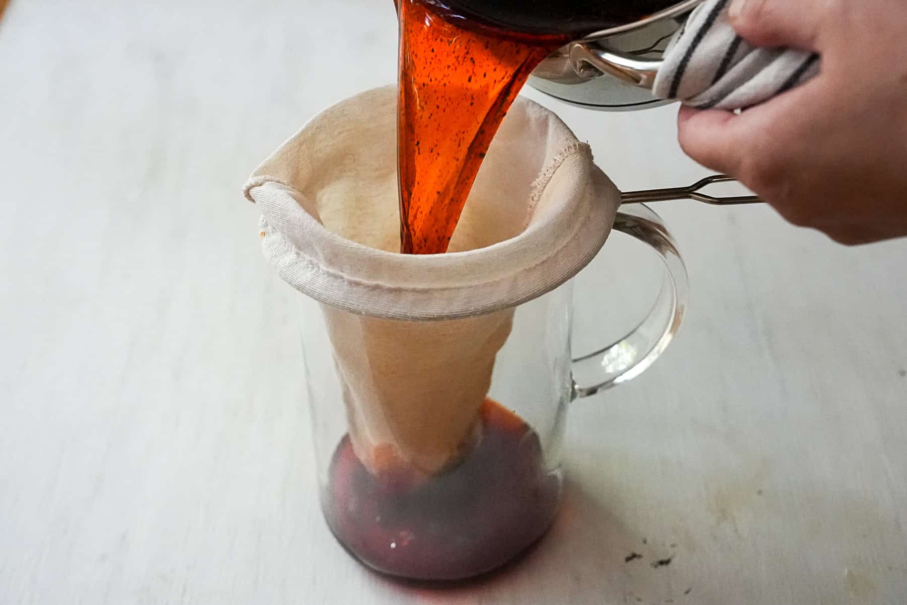 Pour the brewed Thai tea  through the tea sock filter